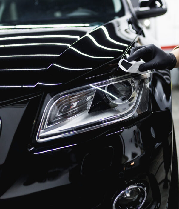 Worker cleaning car - car detailing (or valeting) concept. Selective focus.